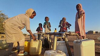 Kinder holen Wasser von der Wasserstelle in Adré