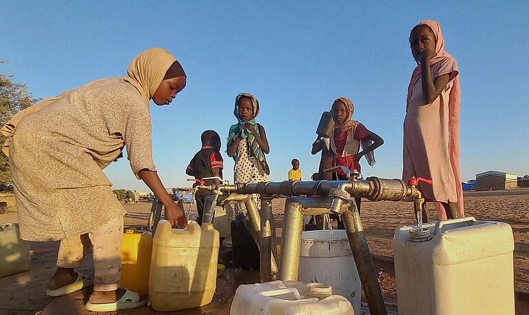 Kinder holen Wasser von der Wasserstelle in Adré