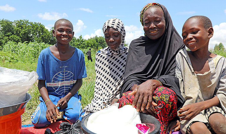 Eine Familie in Niger mit Lebensmittelhilfe, die sie von Plan erhalten hat 