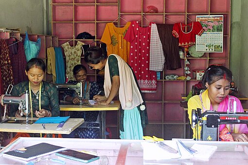 Frauen in Nepal sitzen an Nähmaschinen