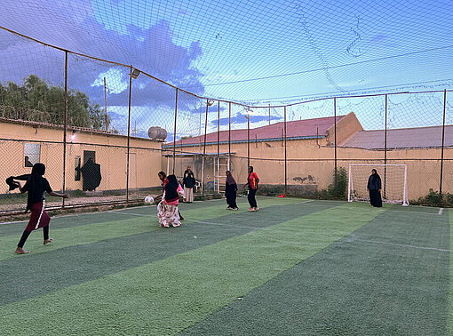 junge Frauen rennen über einen Fußballplatz