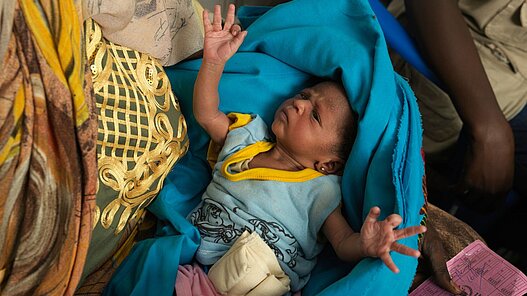 Mutter mit Baby in einer Geflüchtetenunterkunft.