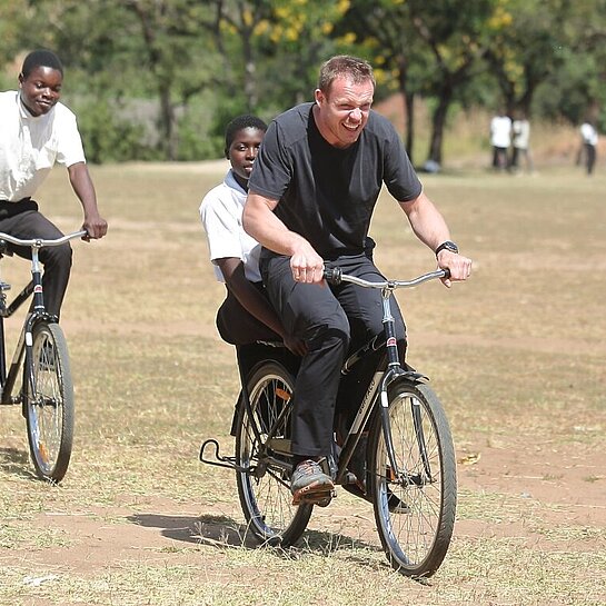 Felix Loch und malawische Kinder fahren Fahrrad