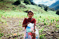 Ein Mädchen trägt ein Hygiene-Kit von Plan International