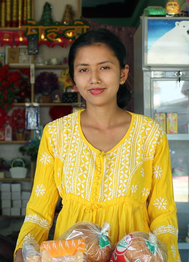 Eine junge Frau steht an einer Ladentheke