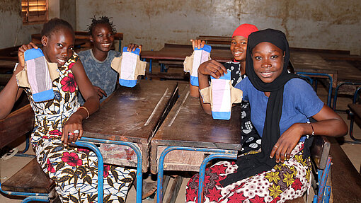 Binden für Bildung Junge Frauen zeigen ihre wiederverwendbaren Binden, die sie in einem Workshop hergestellt haben.