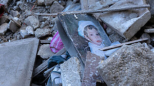 Foto von Kind in Trümmern eines Erdbebens.